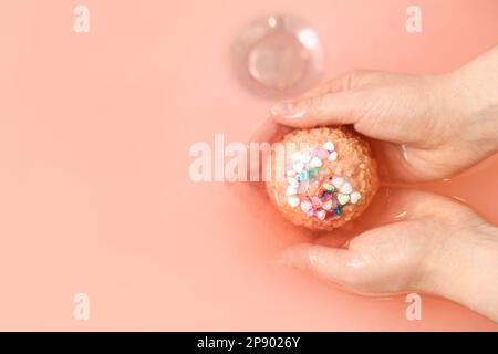 Femme mettant la bombe de bain dans l'eau dans la chambre, gros plan Banque D'Images