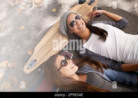 Se détendre au skate Park. deux jeunes femmes avec leurs planches à roulettes dans la ville. Banque D'Images