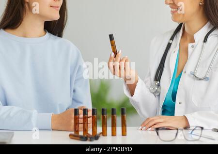 Médecin donnant à base de plantes essentielles à l'huile flacon inhaler femme patient Banque D'Images