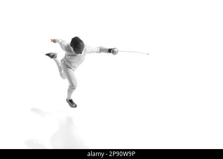 Portrait complet de l'homme sportif, tireur professionnel en costume d'escrime et masque de casque de protection en mouvement isolé sur fond blanc de studio. Banque D'Images