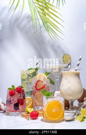 Cocktails d'été boissons. Boissons alcoolisées classiques en version longue, boissons variées, limonades aux baies, citron vert, orange, noix de coco, glace sur le blanc Banque D'Images