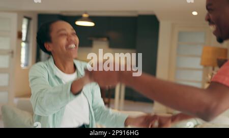 Les jeunes couples heureux dansent ensemble à la musique à la maison, ils blague comme ils sourient et rient dans l'amour à la chambre nouvelle maison. Un couple noir vous offre un moment ludique Banque D'Images