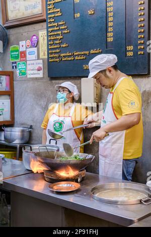 Bangkok Ratchawat Thailand les gens préparent la nourriture de rue thaï dans une cabine de nourriture avec un wok poêle à frire. Banque D'Images