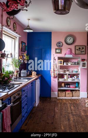 Cuisine rose avec peinture bleue contrastée de la fleur de maïs dans la ferme Tudor du 16th siècle, Suffolk, Royaume-Uni. Banque D'Images