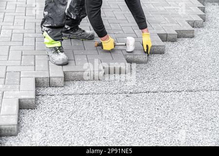 pose de pavés à interverrouillage pendant la construction de trottoirs et de routes Banque D'Images