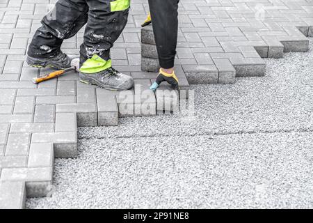 pose de pavés à interverrouillage pendant la construction de trottoirs et de routes Banque D'Images