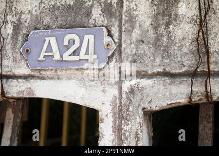 Une plaque de numéro de maison ancienne 24 sur un vieux mur en très mauvais état. Plaque de numéro. Numéro de bâtiment sign Banque D'Images