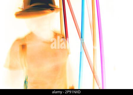 Homme en mouvement flou dans un chapeau dansant à la lumière du néon. Personne sans visage, concept d'identité cachée Banque D'Images