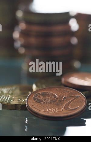 Quelques pièces en euros devant les piles de pièces Banque D'Images