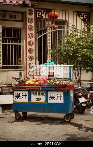 Vendeur de rue panier de fruits tropicaux et de la vente des boissons. Stand en extérieur avec du jus de fruits et autres boissons. Texte sur le décrochage en chinois : Fruit j Banque D'Images