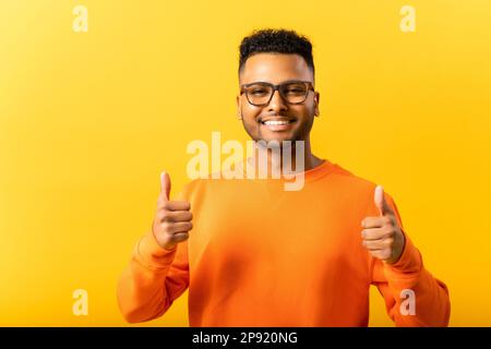 Souriant jeune 20s arabe homme gai et excité, montrant le pouce vers le haut, le concept de succès et d'approbation, ok geste, Indien gars en lunettes d'accord et de recommander, comme le geste de bouton Banque D'Images