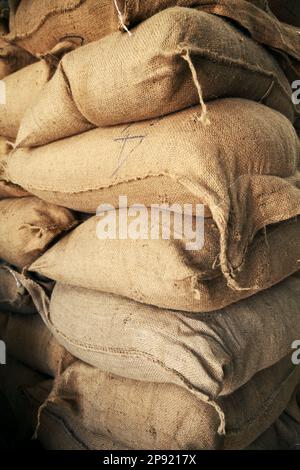 Pile de sacs de toile brune avec grain à un entrepôt. Gros tas de sacs de chanvre plein de récolte le stockage dans une exploitation agricole Banque D'Images