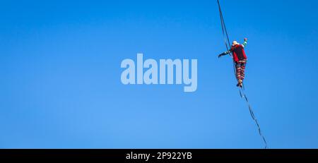 LANZO, ITALIE - VERS OCTOBRE 2020: Athlète de slackline pendant sa performance. Concentration, équilibre et aventure dans ce sport dynamique Banque D'Images