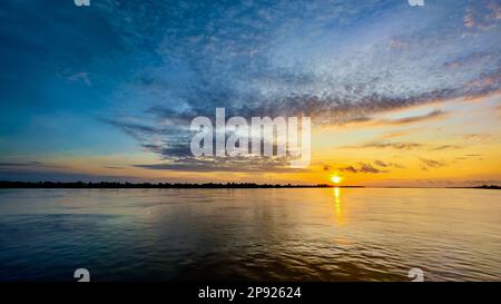 Lever de soleil sur le puissant fleuve Mékong juste en aval de Phnom Penh au Cambodge. Banque D'Images