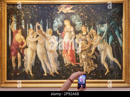 Florence, Italie - vers juillet 2021.Turist prenant la photo de Botticelli - Printemps.Caucasienne mains avec mobile Banque D'Images