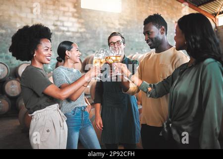 Dégustation de vins entre amis, en dégustant des cheers et des toasts, célébrez avec des verres de champagne dans la cave, la distillerie et la brasserie. Groupe de heureux, diversité et sourire Banque D'Images