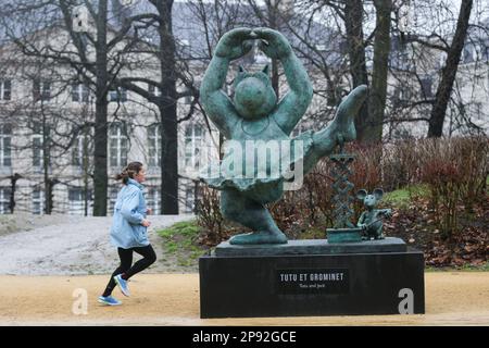 (230310) -- BRUXELLES, 10 mars 2023 (Xinhua) -- Une femme passe par une sculpture du Chat au Parc de Bruxelles à Bruxelles, Belgique, 10 mars 2023. Au total, 22 sculptures du Chat, icône de bande dessinée créée par le caricaturiste belge Philippe Gelack, sont exposées au parc de Bruxelles. L'exposition durera jusqu'à 30 juin. (Xinhua/Zheng Huansong) Banque D'Images