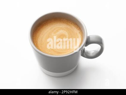 Café crémeux noir frais dans une petite tasse sur du blanc. Banque D'Images