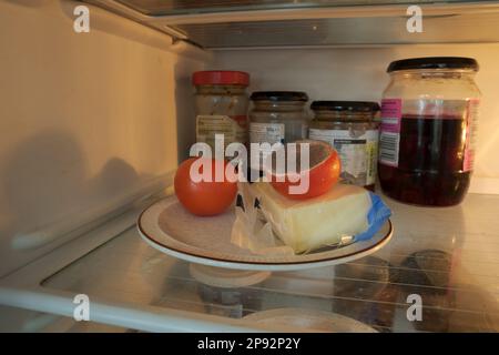 Nourriture oubliée, la tomate sur une plaque dans le réfrigérateur commence à se désintégrer après avoir été infectée par un moule à broches, probablement le bacille de pénicilline, beaucoup de spores mûres Banque D'Images