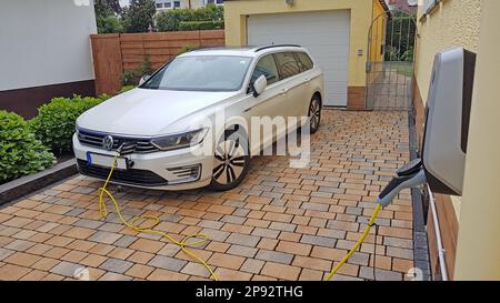 Photo d'une voiture électrique hybride enfichable à la station de charge pendant la journée Banque D'Images