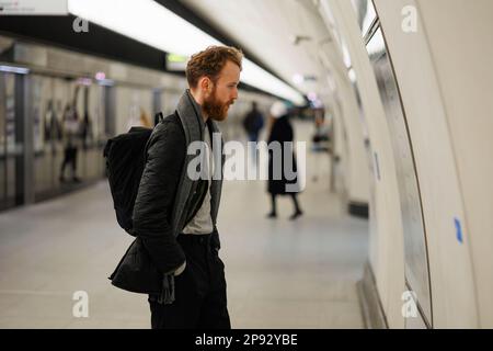 Un homme barbu regarde une carte du métro Banque D'Images