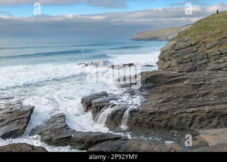 Un couple regarde la marée entrante depuis le sommet des falaises de Trebarwith Strand, sur la côte nord de Cornwall, en Angleterre. Banque D'Images