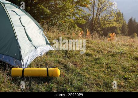 Tapis de couchage près d'une tente de camping à l'extérieur. Équipement de tourisme Banque D'Images