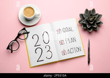 Composition d'un bloc-notes avec texte 2023 but, Plan, action sur fond rose. Objectifs de la nouvelle année Banque D'Images