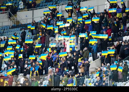 Odessa, Ukraine - novembre 2021 : les fans de football ukrainien dans des stands de stade avec des drapeaux ukrainiens et des attributs nationaux soutiennent avec enthousiasme leur Banque D'Images