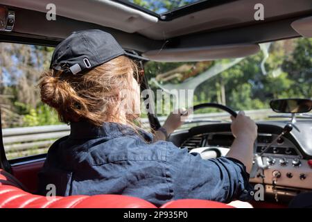 Jeune homme au volant d'un Citroën DS sur une route de campagne Banque D'Images