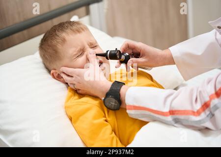 Le pédiatre effectue un diagnostic médical avec otoscope à l'hôpital Banque D'Images