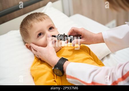 Le pédiatre féminin conduit le nez avec l'otoscope dans l'hôpital moderne Banque D'Images