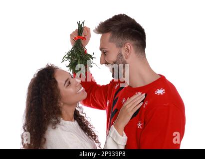 Couple charmant sous le bouquet de GUI sur fond blanc Banque D'Images