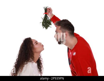 Couple charmant sous le bouquet de GUI sur fond blanc Banque D'Images