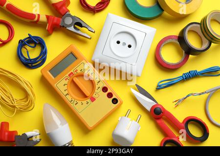 Composition de pose à plat avec outils et accessoires d'électricien sur fond jaune Banque D'Images