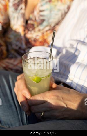 Homme tenant le cocktail caipirinha dans ses mains Banque D'Images