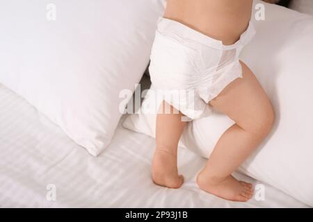 Bébé mignon en couche douce sèche sur lit blanc, gros plan Banque D'Images