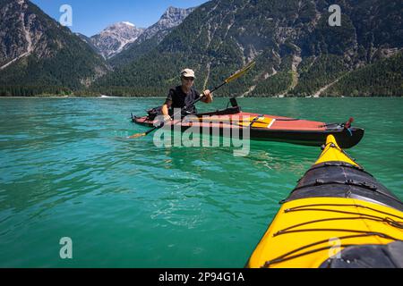 Kayak de mer (60 ans) sur le lac Heiterwang. Banque D'Images