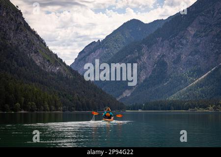 Kayak de mer (60 ans) sur le lac Heiterwanger. Banque D'Images