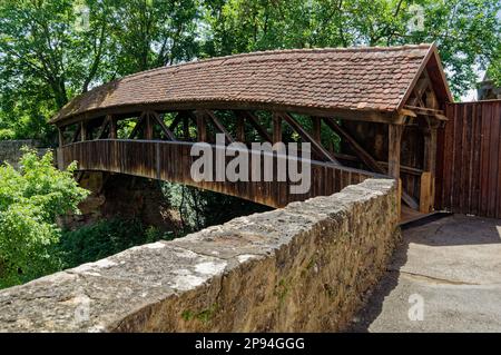 Un pont en bois à Rothenburg ob der Tauber traverse une rivière et est soutenu par deux piliers en pierre Banque D'Images