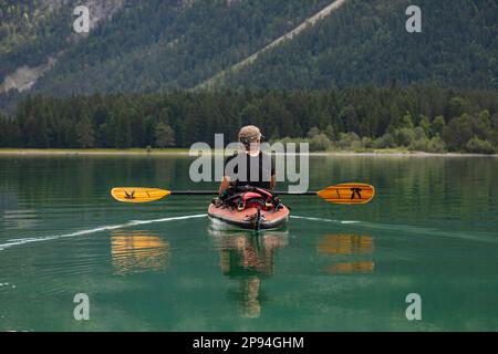 Kayak de mer (60 ans) sur le lac Heiterwang. Banque D'Images