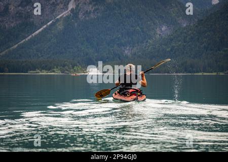 Kayak de mer (60 ans) sur le lac Heiterwang. Banque D'Images