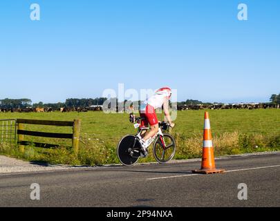 Tauranga Nouvelle-Zélande - 8 janvier 2011; cyclistes participants sur la route dans le port de Tauranga demi-fer-homme le long de la route rurale après la ferme. Banque D'Images