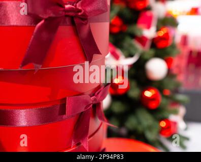 Sapin de Noël décoré, boîtes cadeaux rouges, décorations de Noël, guirlande brillante sur branches vertes, arrière-plan de Noël flou avec espace de copie Banque D'Images