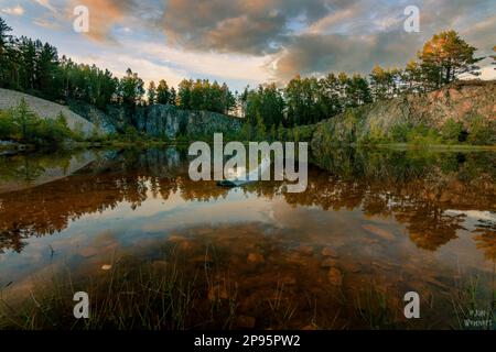 Suède, vue depuis la rive sur le lac, eau calme, lever du soleil avec réflexion dans l'eau Banque D'Images