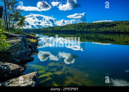 Suède, vue depuis la rive sur le lac, eau calme, lever du soleil avec réflexion dans l'eau Banque D'Images