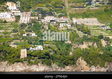 Vue sur la côte amalfitaine avec des logements dispersés et des hôtels vus d'un bateau en direction sud-ouest vers Capr. Tour de guet de Saracen sur la gauche. Banque D'Images