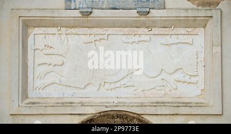 Plaque sculptée sur un mur à l'extérieur de Chiesa di Santa Maria Assunta, Positano, Salerne, côte amalfitaine, Italie créatures de la mer, poissons et animaux en bas relief. La sculpture médiévale comprend un pistage, qui est un demi-dragon mythique, un demi-chien, à côté d'un poisson et d'un renard. Il est situé dans le mur au-dessus de la porte du clocher de l'église de Santa Maria Assunta à Positano, en Italie Banque D'Images