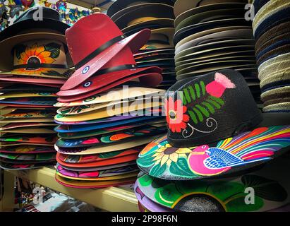 Beaucoup de chapeaux colorés dans plusieurs piles verticales, en vente dans une boutique touristique avec des articles du Mexique. Banque D'Images