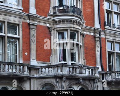 Ancien immeuble élégant avec balcons en pierre ronde très ornés sous les fenêtres Banque D'Images